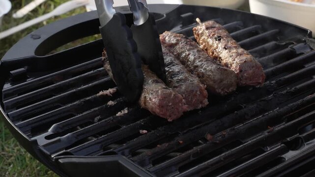 Minced beef or lamb kebabs grill, sear and smoke over hot charcoal outdoors in real time, barbecue cuisine, summer cookout