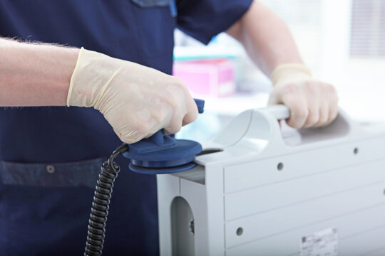 Discharge electrodes in hands of an intensive care doctor. Defibrillator is in hands of resuscitator. Electropulse therapy of cardiac arrhythmias. Intensive care. Saving patient's life