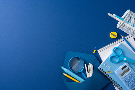 Back to school blue stationery flat lay with notebook, calculator, scissors and supplies