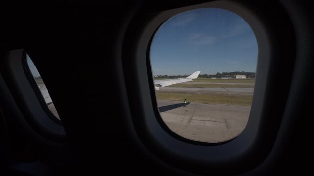 Static cockpit window view of airport runway and ground crew