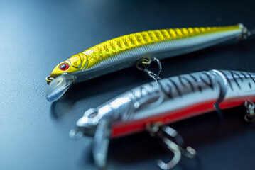 Close up of silver and gold fish lures on dark background The Concept of catching fish © VicVaz