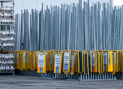 View of a large collection of yellow parking signs with blue P symbols mounted on metal poles stored in a depot in Zaandam, North Holland, Netherlands.