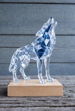 Crystal polygonal wolf sculpture howling on a wooden base stand