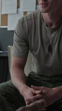Vertical video of young adult Caucasian male soldier talking and gesturing with hands during counseling session. Footage for veteran mental health support and therapy services