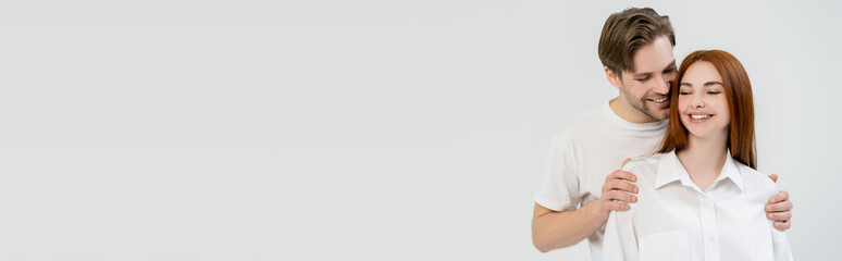 Obraz premium A young couple enjoys a tender embrace, exchanging smiles and love in a bright, cheerful space.