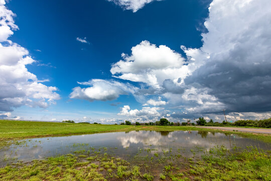 View of a flooded field reflecting dramatic storm clouds in the sky in Oklahoma City, Oklahoma, United States.