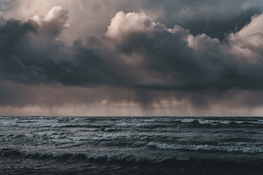 View of the stormy Baltic Sea off the coast of Vormsi with dark, heavy rain clouds and rough, churning waves under a dramatic, moody sky in Laane County, Estonia.