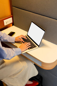 Business woman using laptop with white screen at modern desk mockup