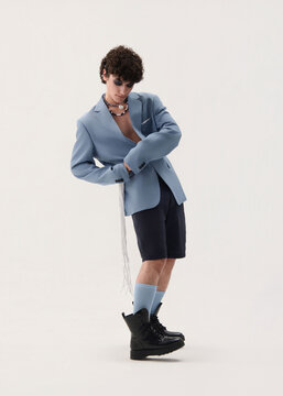 A young boy in a blue jacket rocking on a white background.