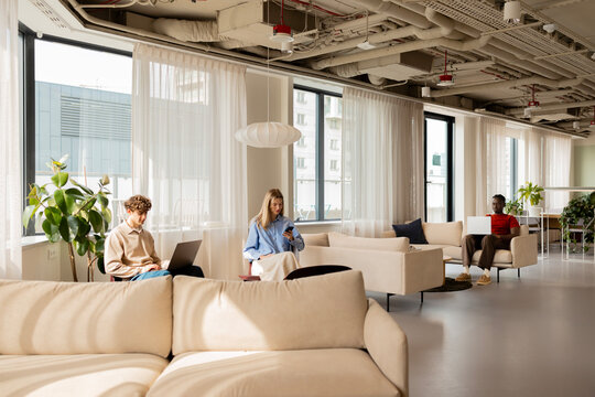 People using laptops and smartphone in modern office coworking space
