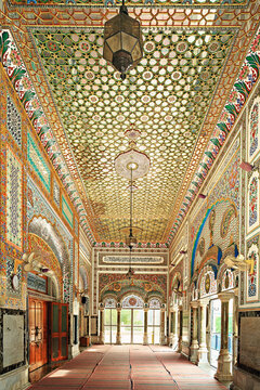 View of the ornate interior of Jamia Masjid Bhong Sharif featuring intricate tile work, geometric ceiling patterns, and hanging lanterns in Bhong, Punjab, Pakistan.