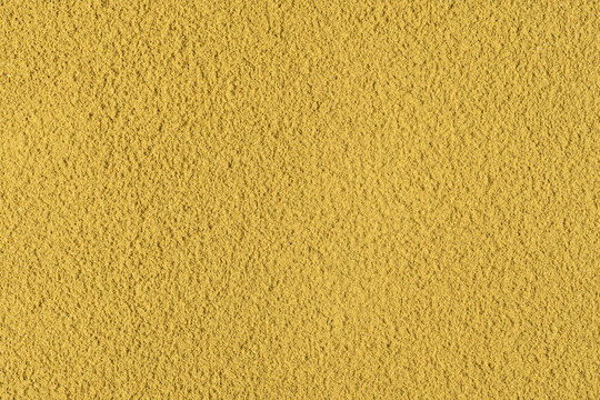 Golden hojicha powder fills frame with warm granular texture for tea packaging, culinary design, wellness branding and backgrounds.