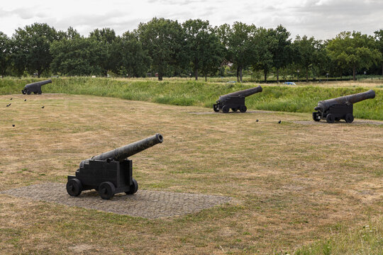 View of historic iron cannons positioned on the grassy ramparts of the old fortification in Heusden, North Brabant, Netherlands.