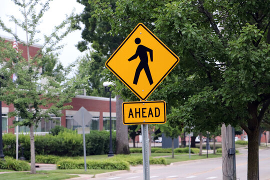 Yellow pedestrian crosswalk ahead warning sign on street side