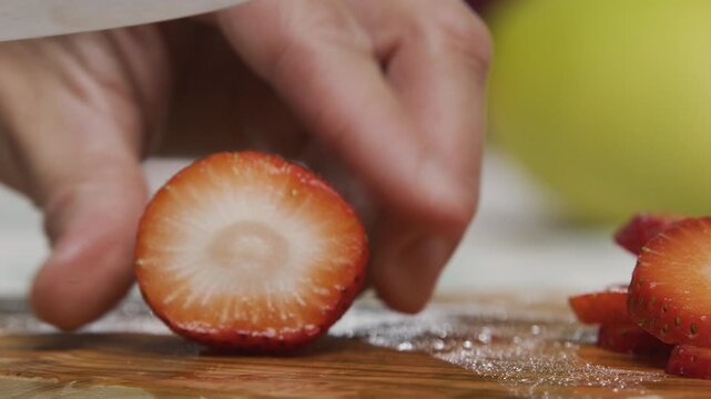 Small knife slicing through delicious, juicy strawberry - extra closeup shot