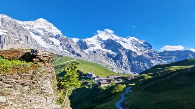 Swiss flag on wooden view platform Kleine Scheidegg Switzerland 4K. Hiking trail towards railway station with snowy peaks in background. Scenic Bernese Oberland travel b-roll stock video