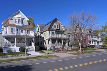 Obraz premium suburban street of three story clapboard houses with large verandas