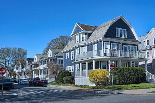 suburban street of three story clapboard houses with large verandas