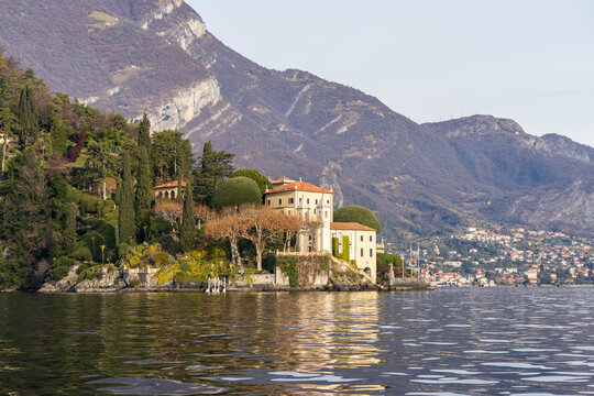 View of the historic Villa Monastero with its lush gardens and cypress trees situated on the shores of Lake Como in Varenna, Lombardia, Italy.