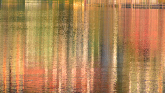 An abstract image in ochre tones of a landscape reflected in the lake.