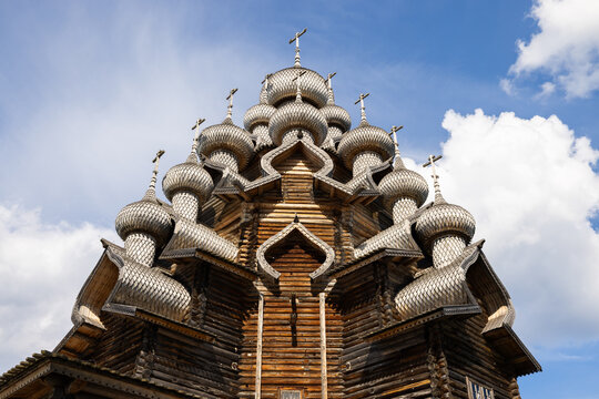 View of the intricate wooden domes and traditional architecture of the Kizhi Pogost church against a blue sky in Petrozavodsk, Republic of Karelia, Russia.