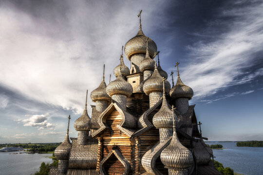 View of the wooden Church of the Transfiguration at Kizhi Pogost with its iconic multiple domes under a dramatic cloudy sky in Petrozavodsk, Republic of Karelia, Russia.