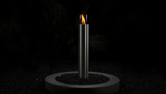 Modern outdoor torch with fire flame. Stainless steel garden lamp on dark gravel background.