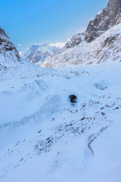 View of the Mer de Glace glacier surrounded by snow-covered mountain peaks under a clear blue sky in Chamonix, Auvergne-Rhone-Alpes, France.