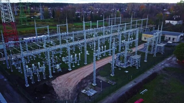 Aerial view of electrical substation with metal structures, power lines, and transformers in Riga, Latvia.