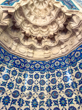 Intricate geometric ceiling design with colorful tile work featuring floral patterns in a historic architectural setting