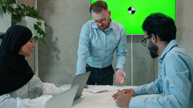 Multiethnic business team brainstorming indoor office boardroom discussing project corporate colleagues businessmen muslim hijab businesswoman talk meeting screen chroma key interactive board mock up