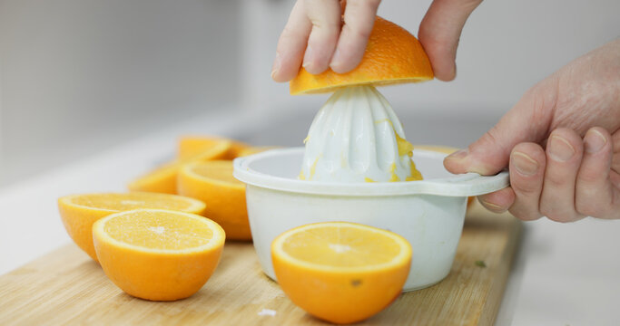 Hands extracting fresh orange juice for a healthy beverage