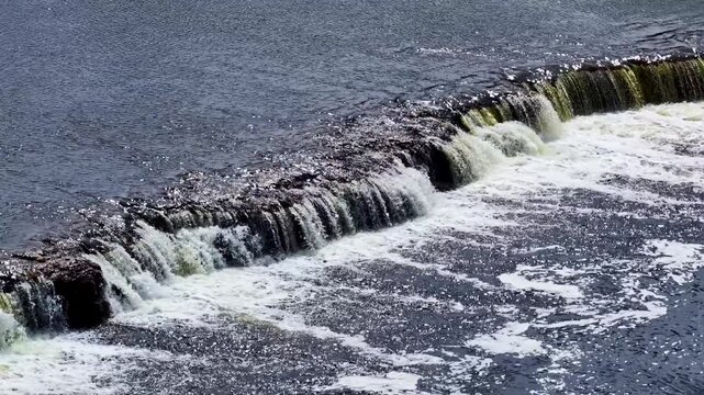 Aerial view of Venta waterfall, the widest waterfall in Europe, with water cascading over the limestone ledge in Kuldiga, Kuldigas novads, Latvia.