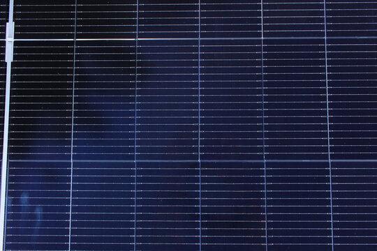 solar panel surface featuring deep blue photovoltaic cells and thin grid lines, representing renewable energy and sustainability.
