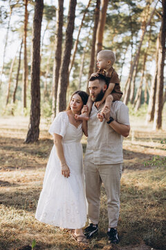 Young parents with their small child having a walk in nature, spending quality time together outside