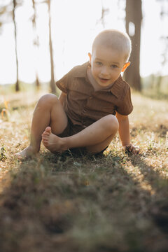 Little boy playing barefoot in grass, embracing childhood freedom on a sunny summer day in nature