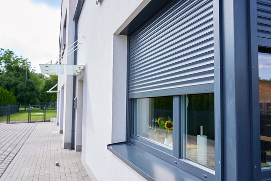Roller shutter partly covers window on the exterior of modern house