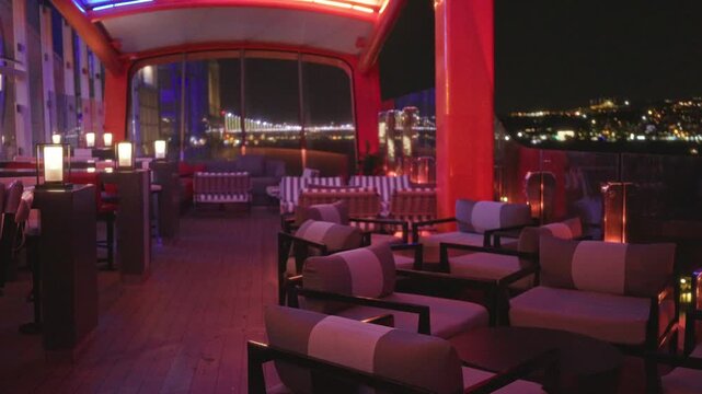 Cruise deck lounge in soft bokeh with blurred city lights and shallow focus outdoor background; background backplate template calm.