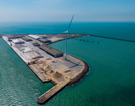 Aerial view of a wind turbine standing on the industrial pier at the port of Boulogne-sur-Mer, Hauts-de-France, France.