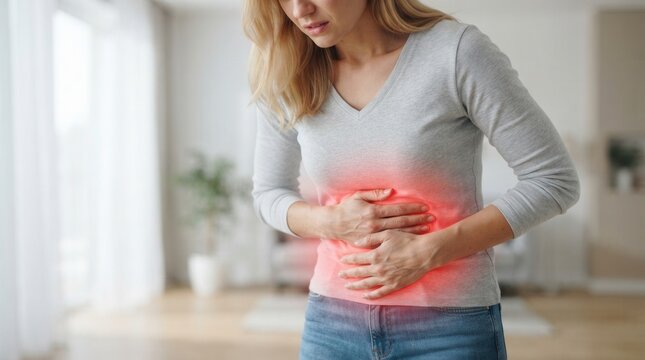 Woman with digestive issues and stomach ache, grimacing in pain while clutching her abdominal area with red glow highlights.