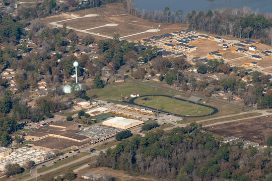 Huffman, Texas, USA - January 10, 2024 - Aerial view of Huffman Elementary and Copeland Elementary schools in the Huffman Independent School District, with an athletic track, school bus fleet
