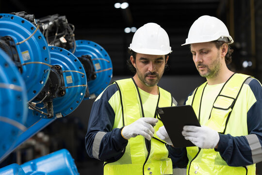 Robotics industry, training and development. Team of male engineer using digital tablet inspecting and connect to robotics arm system for testing and development solutions