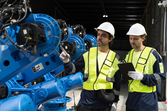 Robotics industry, training and development. Team of male engineer using digital tablet inspecting and connect to robotics arm system for testing and development solutions