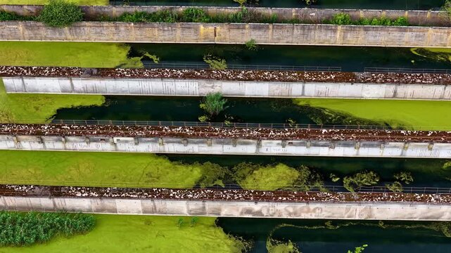 Aerial view of industrial concrete channels filled with green algae and water in Riga, Latvia.