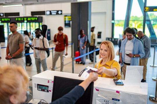 Young woman checking in at airport with passport and boarding pass