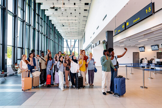 Diverse group of friends traveling together in airport terminal