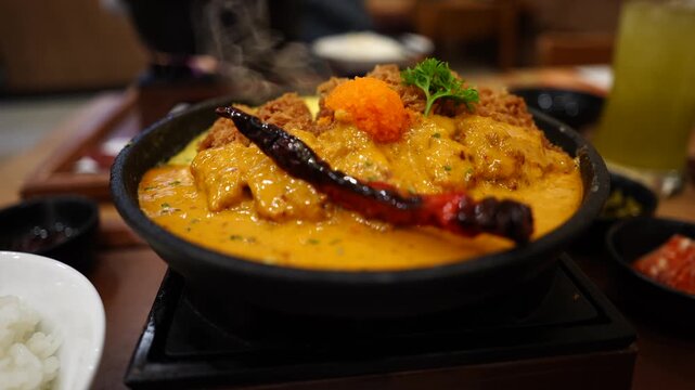 The dish features crispy fried cutlets chicken served on top of creamy scrambled eggs ("Kai Khon") and smothered in a rich, savory shrimp paste sauce.