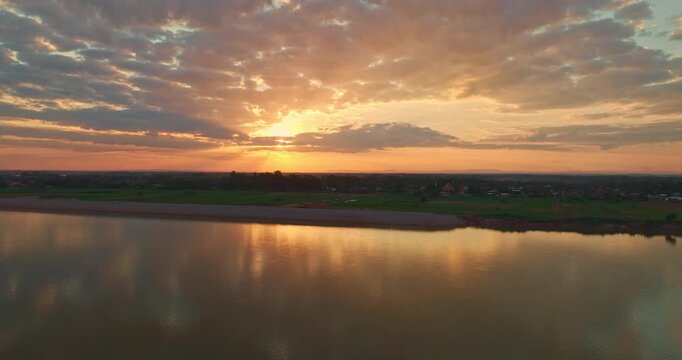 An aerial hyperlapse This breathtaking aerial view highlights the harmony between the Mekong River and surrounding farmland at dusk. Dramatic Evening Skies Above Mekong Riverside Countryside