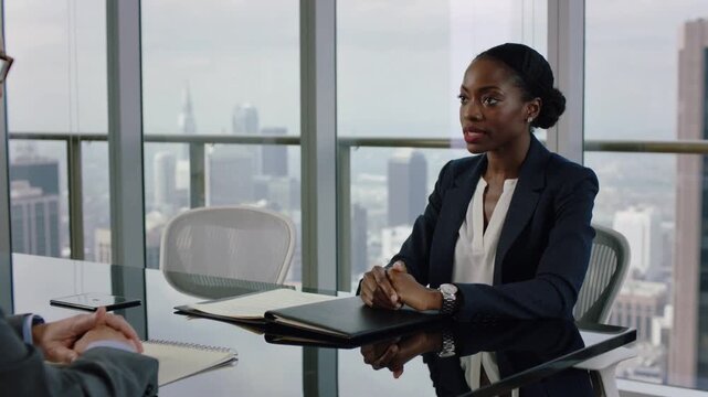 Opening black folder, woman in navy blazer sliding papers, gesturing to secure job in office