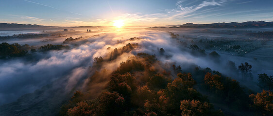 Fototapeta premium Scenic Drone View of a Tranquil Misty Sunrise Over Rural Wilderness Landscape Featuring Colorful Sky and Forest